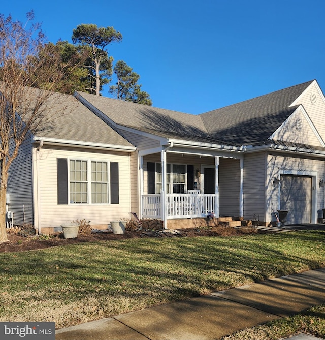 view of front of property with a garage, a front lawn, and a porch