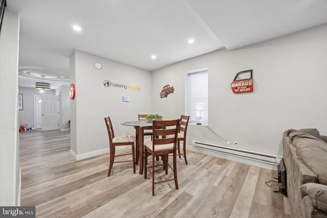 dining area with a baseboard radiator and light wood-type flooring