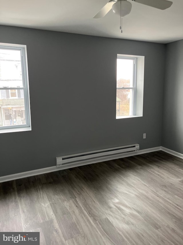 empty room featuring a baseboard heating unit, hardwood / wood-style flooring, and ceiling fan