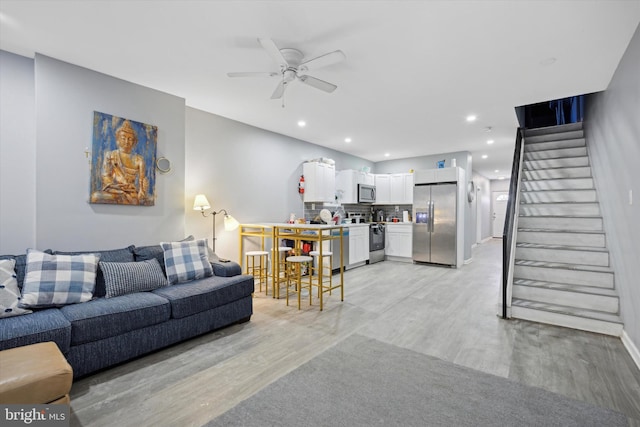 living room with ceiling fan and light wood-type flooring