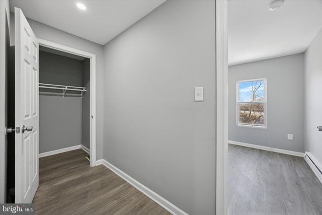 hallway with dark hardwood / wood-style flooring and baseboard heating