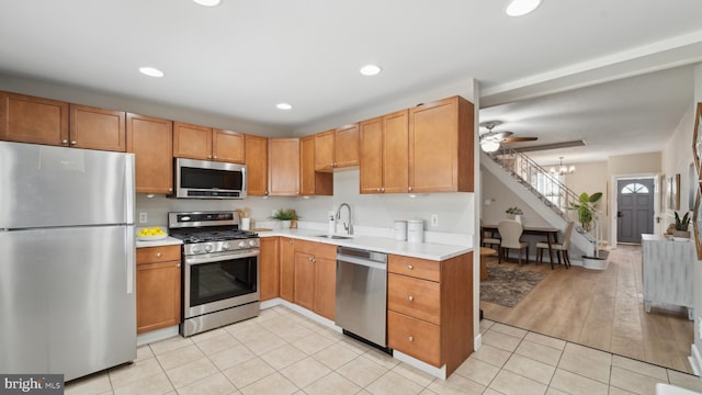 kitchen featuring light tile patterned flooring, appliances with stainless steel finishes, sink, and a notable chandelier