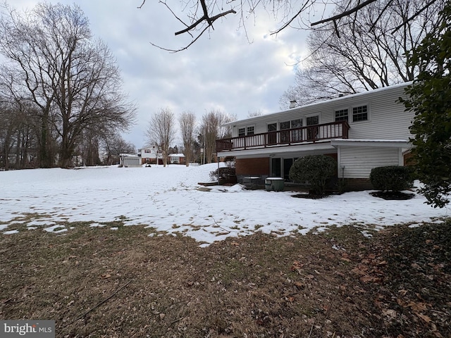 snow covered house featuring a wooden deck