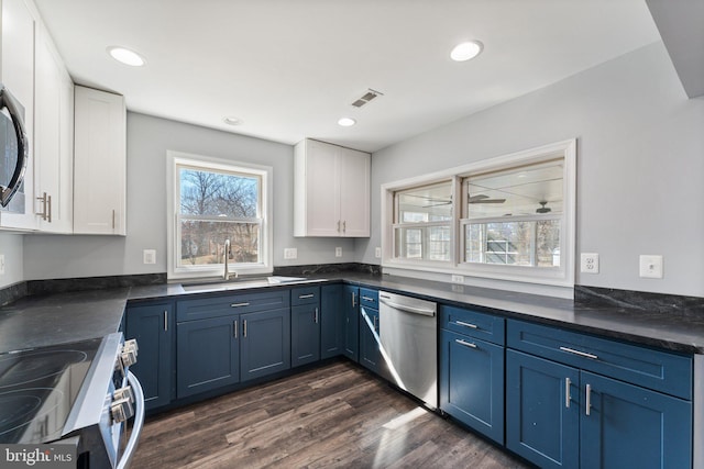 kitchen with sink, blue cabinetry, white cabinetry, and stainless steel appliances