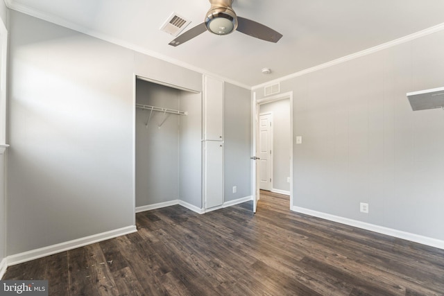 unfurnished bedroom featuring ceiling fan, dark wood-type flooring, crown molding, and a closet