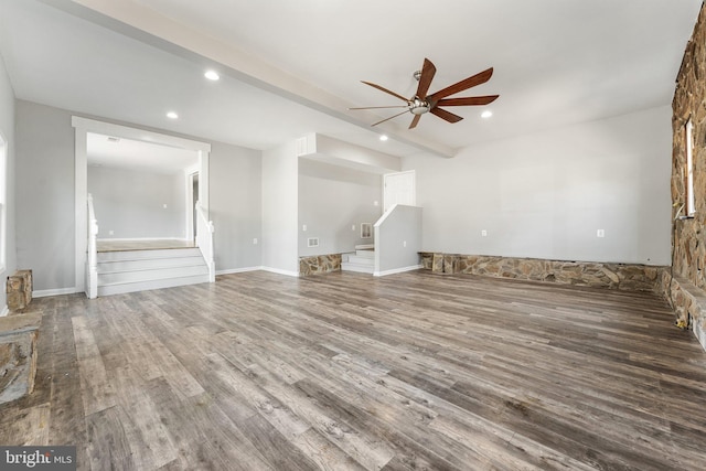 unfurnished living room with hardwood / wood-style flooring, ceiling fan, and beam ceiling