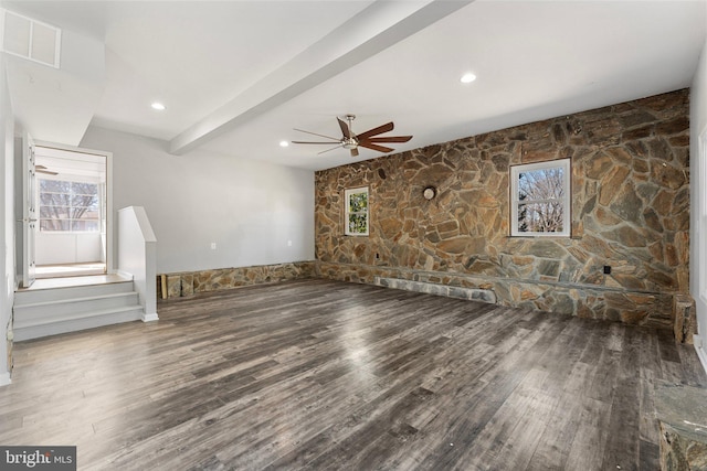 unfurnished living room with beamed ceiling, ceiling fan, and wood-type flooring