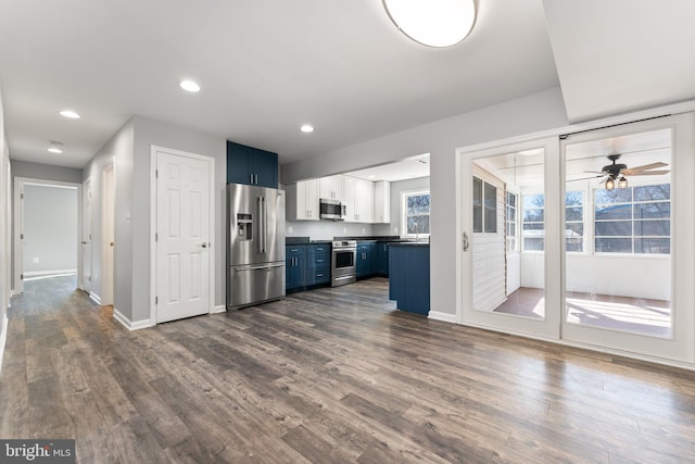 kitchen with white cabinetry, dark hardwood / wood-style flooring, stainless steel appliances, and blue cabinets