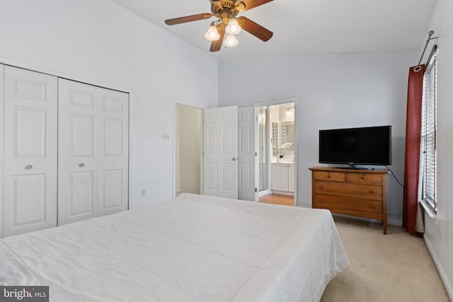 carpeted bedroom featuring ensuite bath, vaulted ceiling, a closet, and ceiling fan