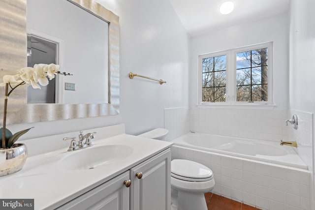 bathroom featuring vanity, tile patterned floors, tiled bath, and toilet