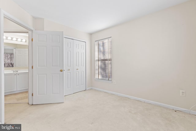 unfurnished bedroom featuring light colored carpet and a closet