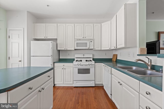 kitchen featuring white cabinetry, sink, and white appliances