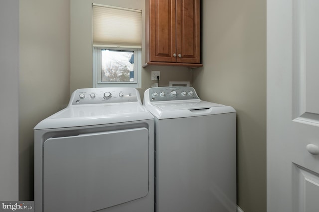 laundry room featuring cabinets and washer and dryer