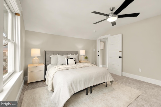 carpeted bedroom featuring ceiling fan, vaulted ceiling, and multiple windows