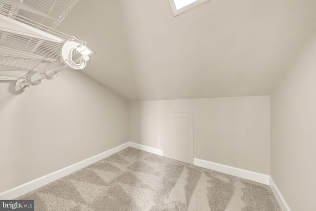 bonus room with vaulted ceiling and carpet flooring