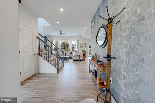 foyer entrance featuring ceiling fan and light wood-type flooring