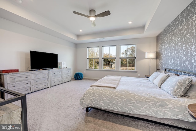 bedroom featuring a raised ceiling, carpet floors, and ceiling fan