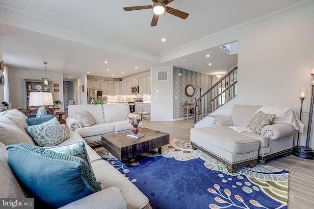 living room with ceiling fan, ornamental molding, and hardwood / wood-style floors