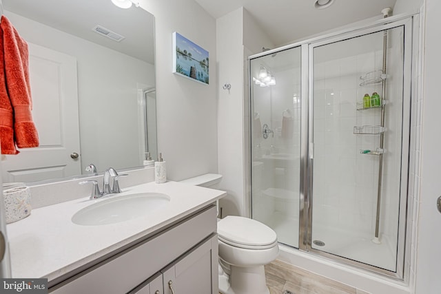 bathroom featuring vanity, toilet, and walk in shower