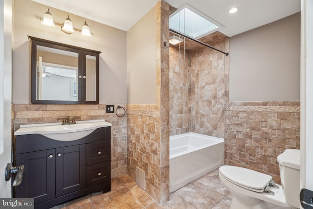 bathroom featuring tile walls, vanity, and toilet