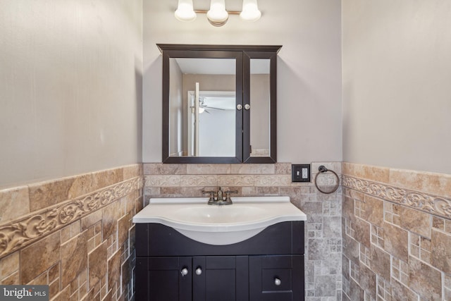 bathroom featuring vanity and tile walls