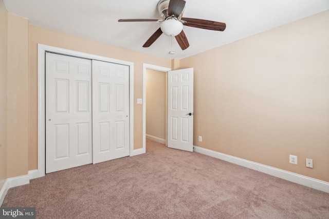 unfurnished bedroom featuring light colored carpet, ceiling fan, and a closet