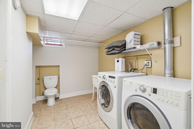 laundry area with independent washer and dryer and light tile patterned floors