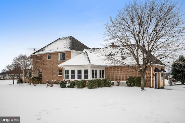 snow covered rear of property with central air condition unit