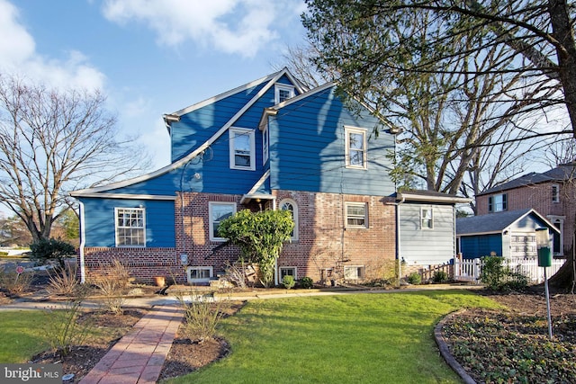 view of front of house featuring brick siding and a front lawn