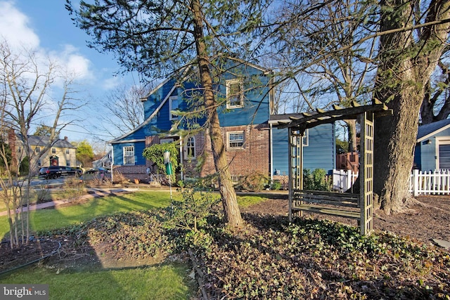 view of front facade featuring fence and brick siding