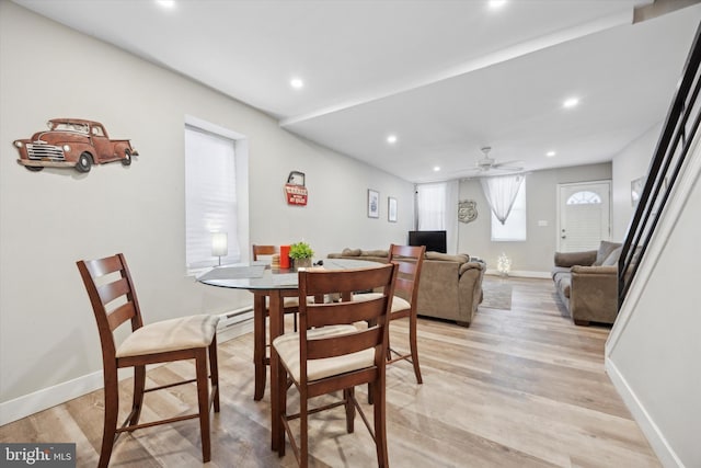 dining space featuring a baseboard heating unit, light hardwood / wood-style floors, and ceiling fan