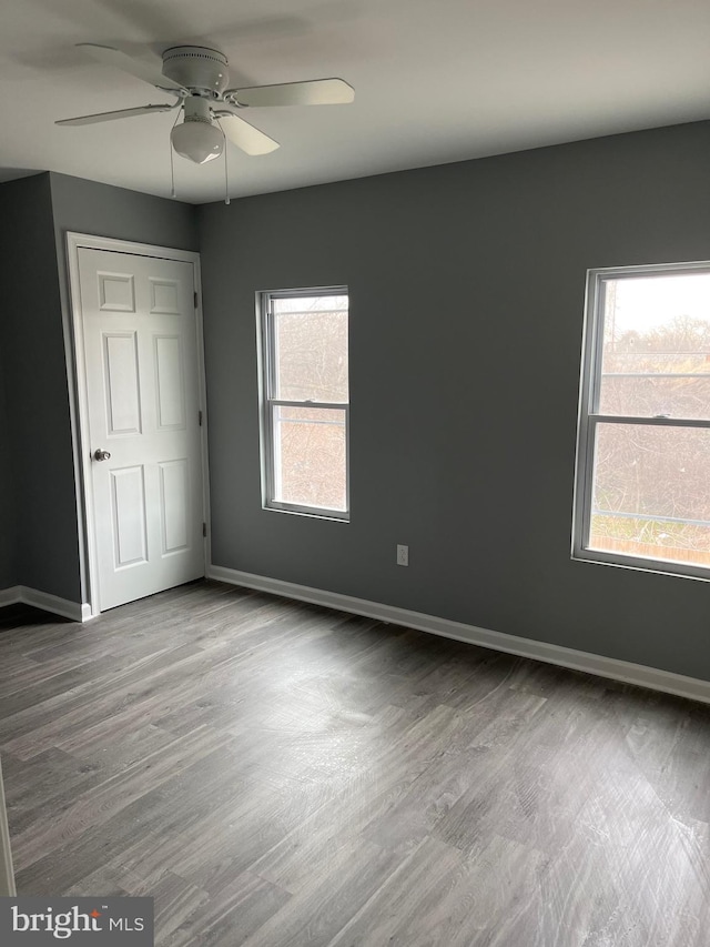 spare room with hardwood / wood-style flooring, ceiling fan, and plenty of natural light