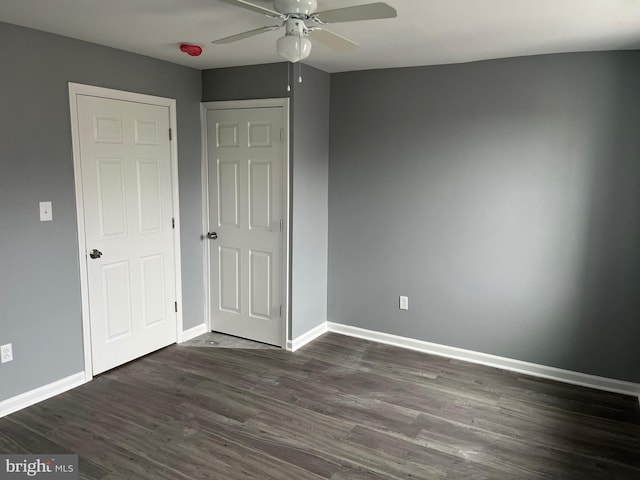 unfurnished bedroom featuring ceiling fan and dark hardwood / wood-style flooring