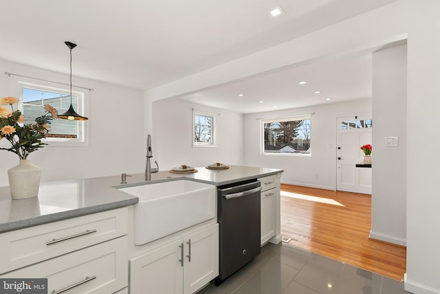 kitchen featuring sink, white cabinetry, hanging light fixtures, light hardwood / wood-style flooring, and dishwasher