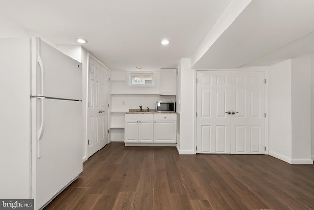 kitchen with sink, dark wood-type flooring, white cabinets, and white refrigerator