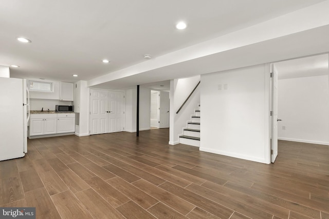 basement featuring dark hardwood / wood-style flooring and white fridge