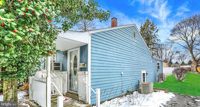 view of property exterior with cooling unit and a yard