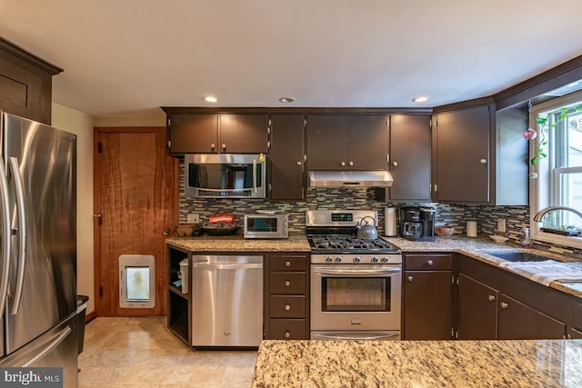 kitchen with dark brown cabinetry, sink, tasteful backsplash, and appliances with stainless steel finishes