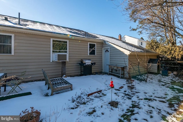 snow covered house featuring cooling unit