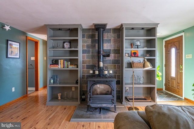 sitting room with a wood stove and light hardwood / wood-style flooring