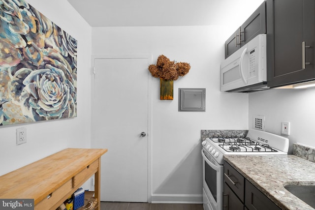 kitchen featuring light stone counters and white appliances