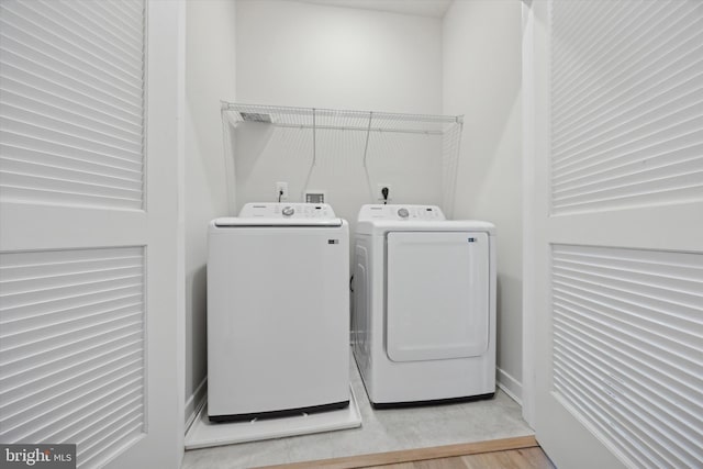 laundry room with wood-type flooring and washing machine and dryer