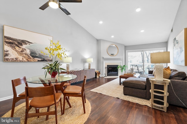 living room featuring dark hardwood / wood-style flooring, high vaulted ceiling, and ceiling fan