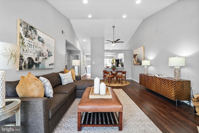 living room featuring vaulted ceiling, dark hardwood / wood-style floors, and ceiling fan