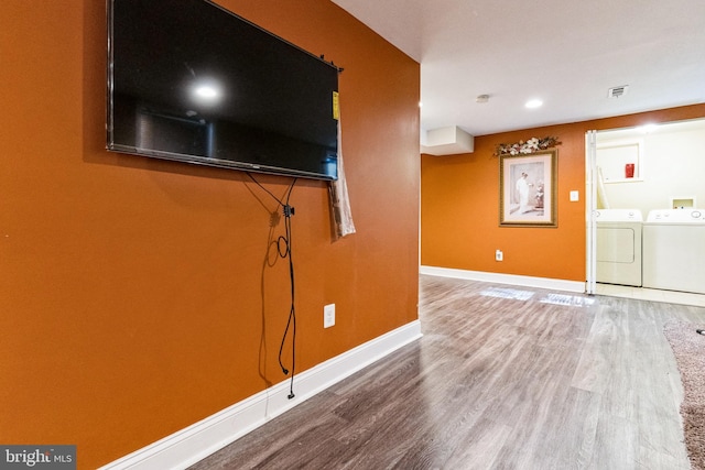 unfurnished living room with wood-type flooring and independent washer and dryer