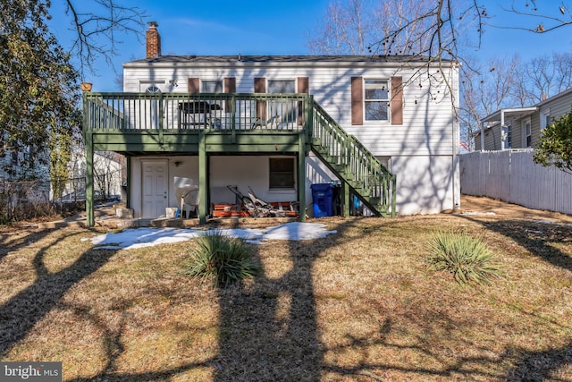 back of house featuring a wooden deck and a lawn