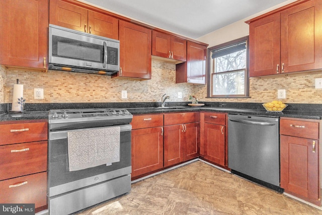 kitchen with appliances with stainless steel finishes, sink, backsplash, and dark stone counters