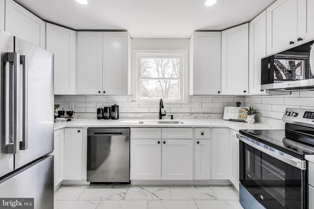 kitchen with marble finish floor, white cabinetry, stainless steel appliances, and a sink