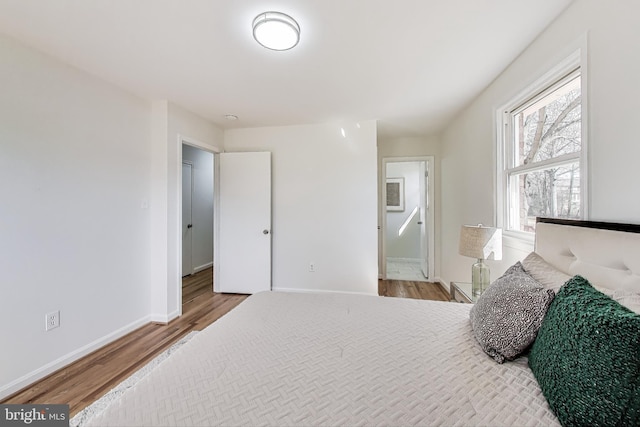 bedroom featuring baseboards and wood finished floors