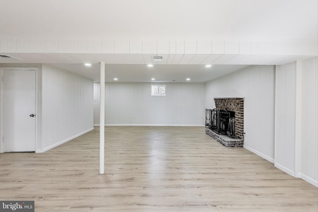 below grade area with visible vents, wood finished floors, recessed lighting, a fireplace, and baseboards